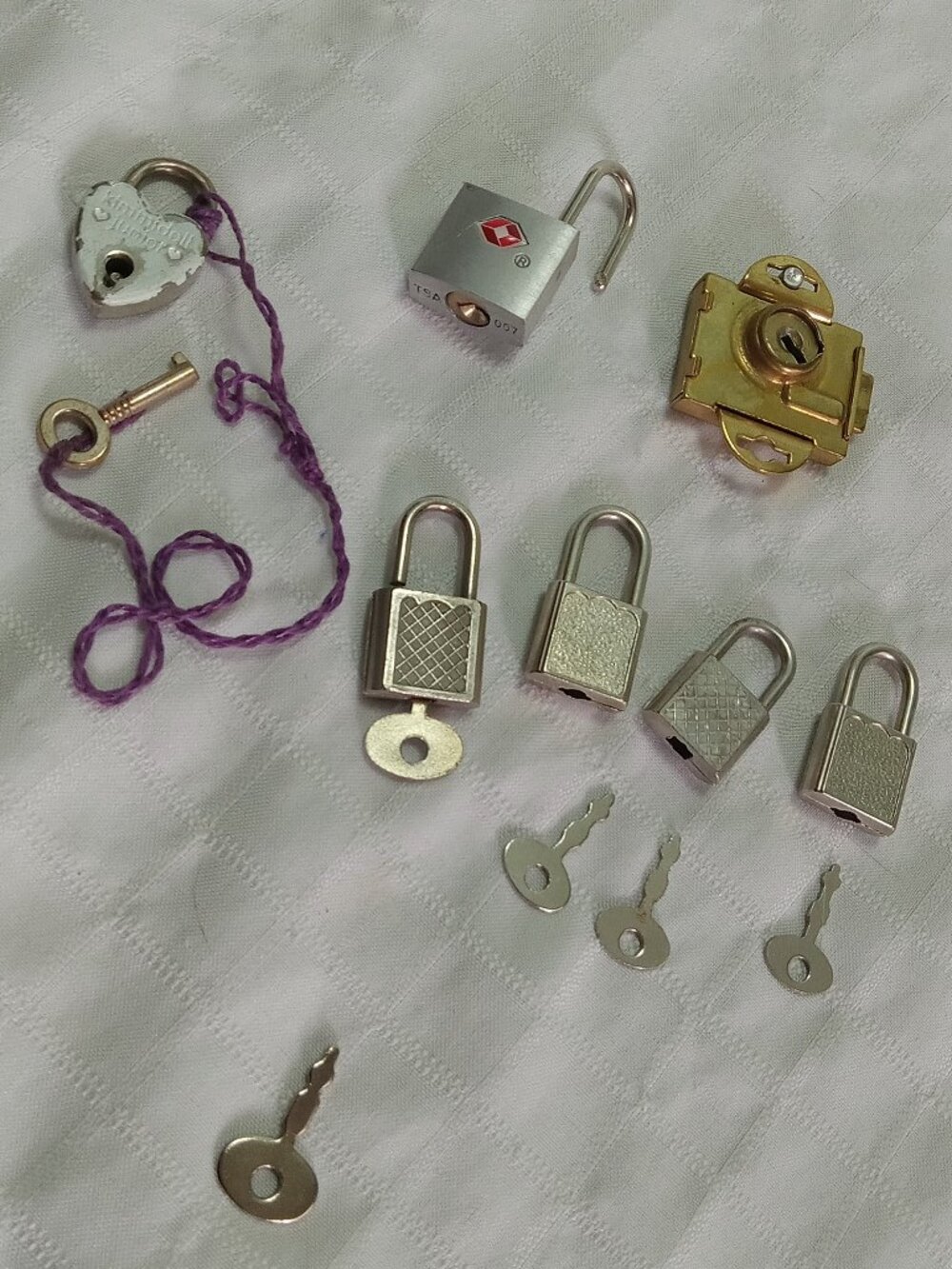 A selection of 7 little locks and keys in a silver color/2 keys are missing